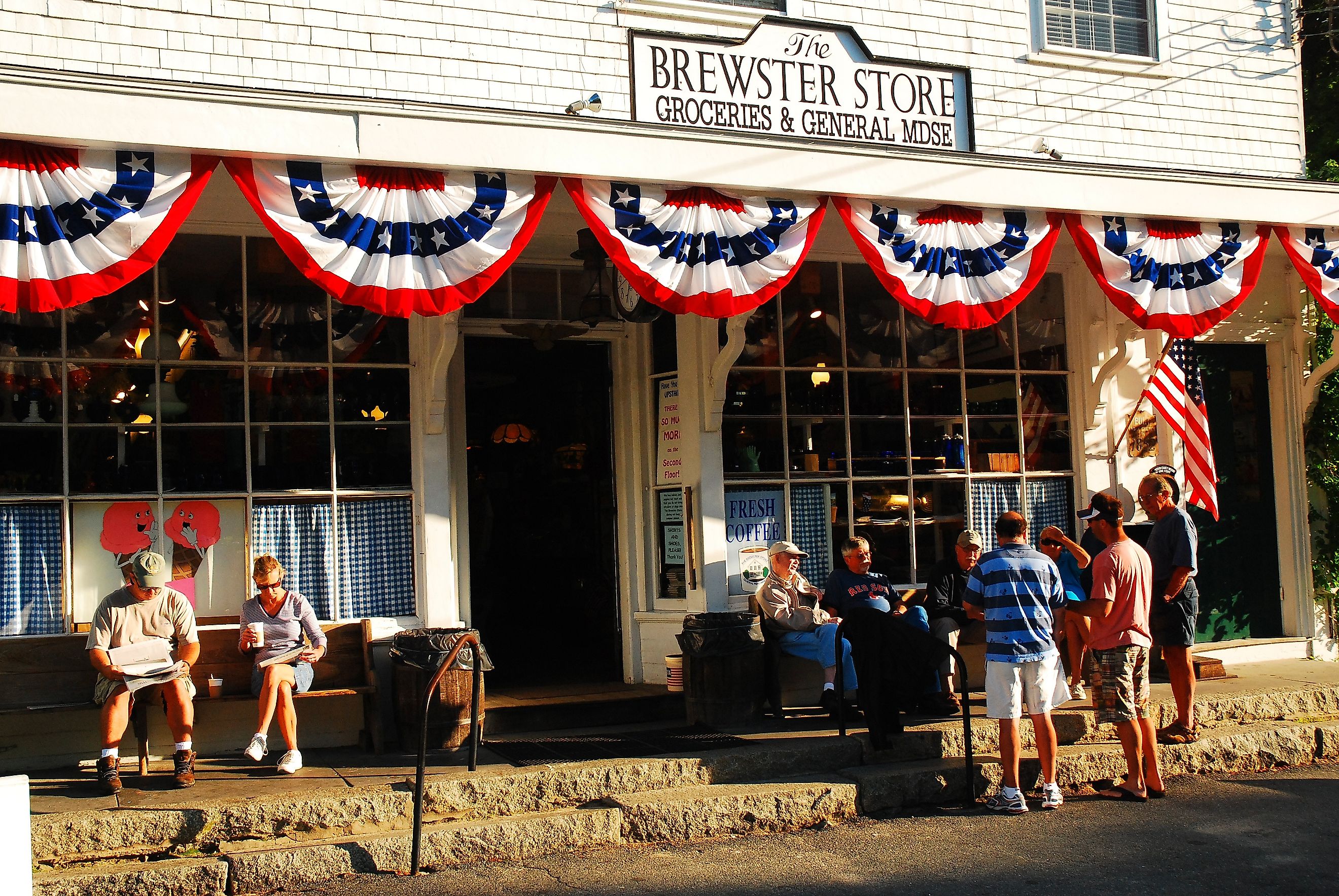 People gather and talk to friends in front of the general store in Brewster, Massachusetts, on Cape Cod, on a sunny summer day. Editorial credit: James Kirkikis / Shutterstock.com
