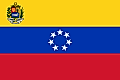 Yellow, blue, and red horizontal flag with official seal in canton and seven white stars forming a circle on blue